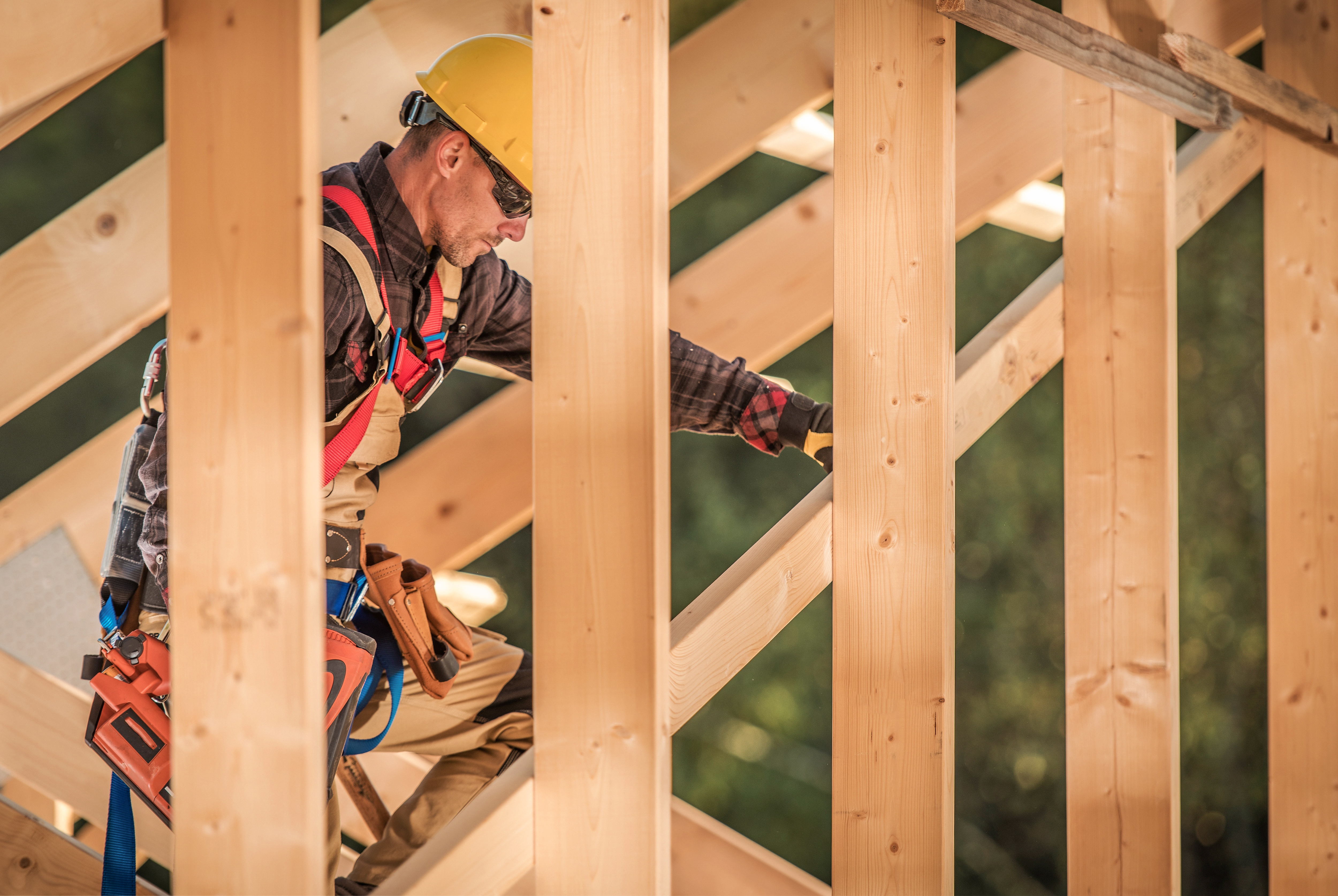 Versicherungen beim Hausbau Detailansicht Dachstuhl Bauarbeiter
